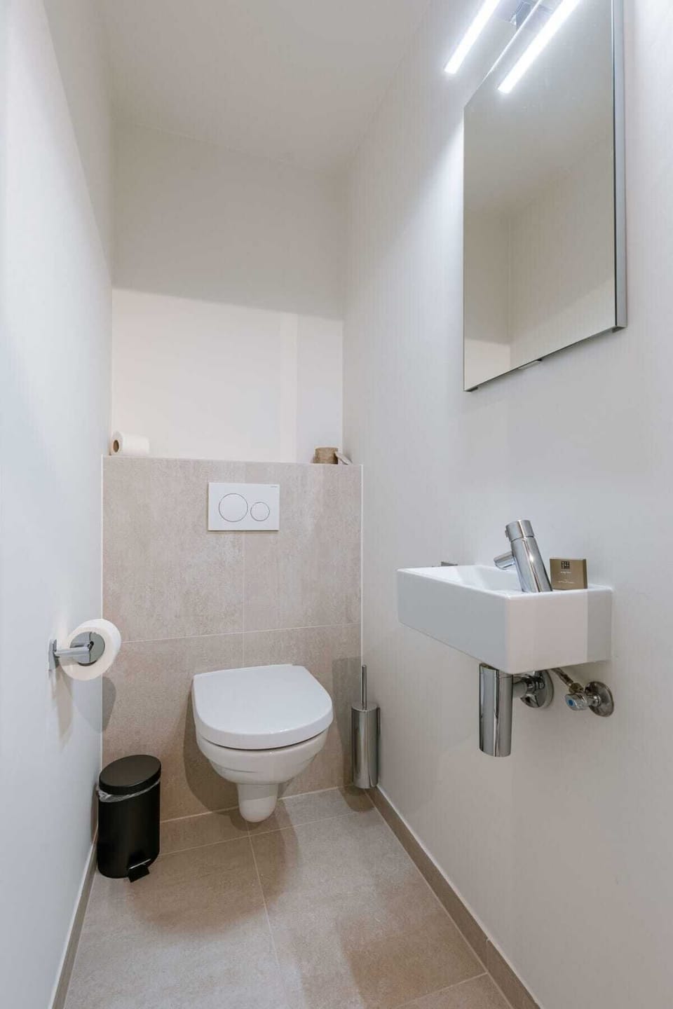 Compact modern bathroom with wall-mounted toilet and sink