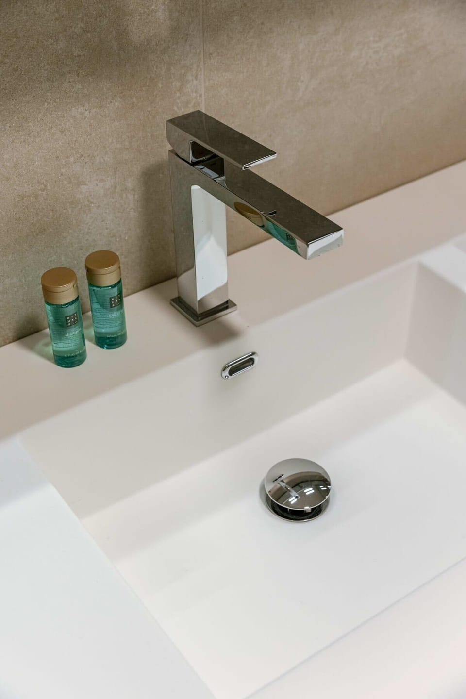 Modern bathroom sink with a sleek chrome faucet and complimentary toiletries.