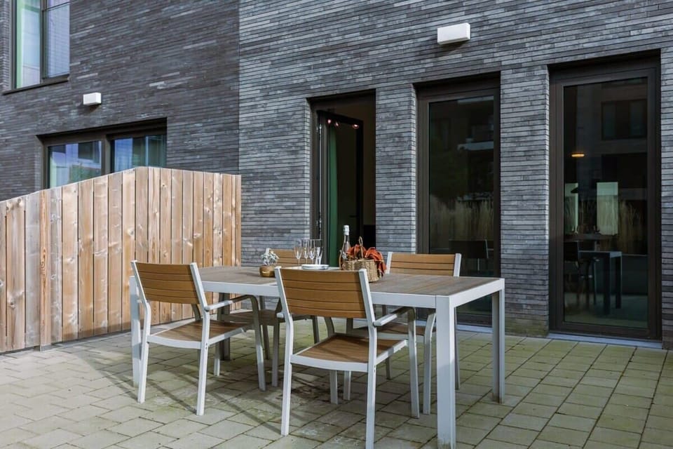 Outdoor patio with modern dining table and chairs for relaxing meals.