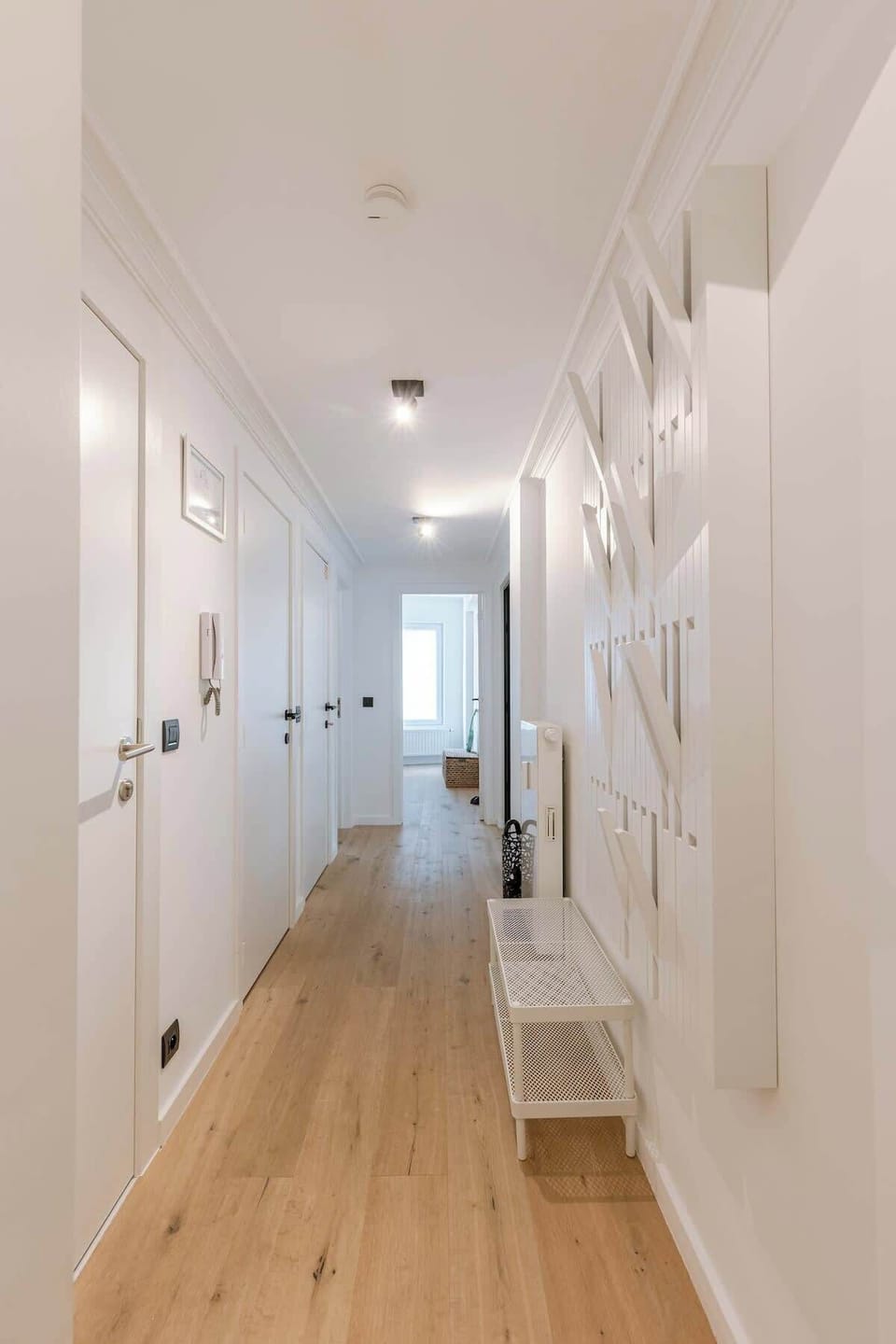 bright hallway with wood flooring and modern wall decor