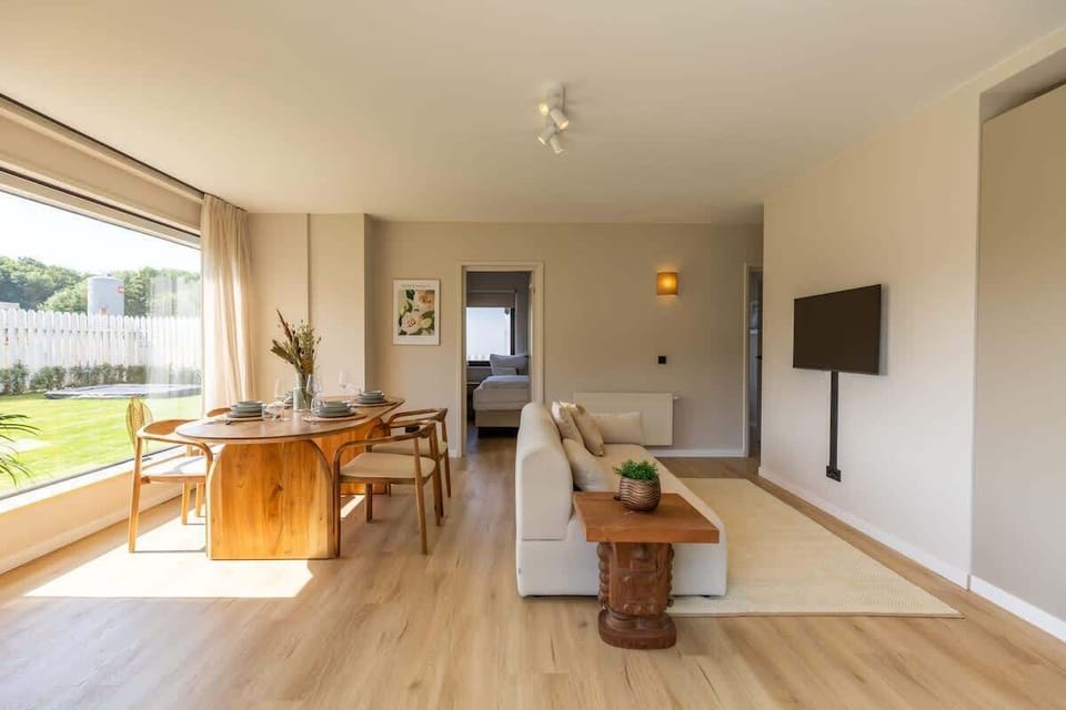 Modern living and dining area with large window overlooking the garden