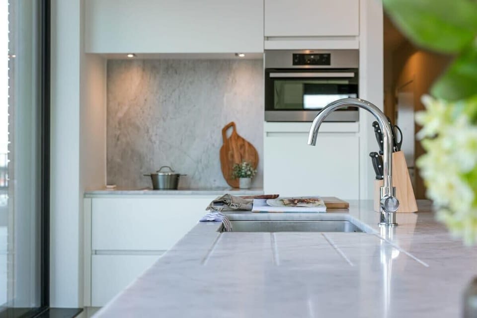 Stylish kitchen corner with marble details and natural light.