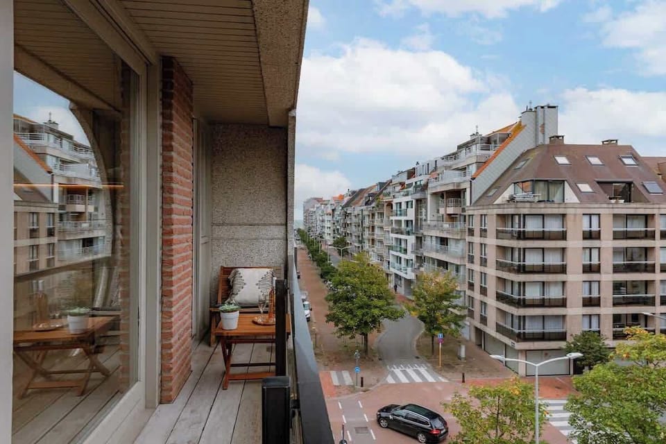 Relax on the balcony with views of the tree-lined street and surrounding modern buildings.