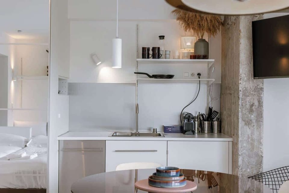Modern kitchen area with open shelving and a compact dining table.