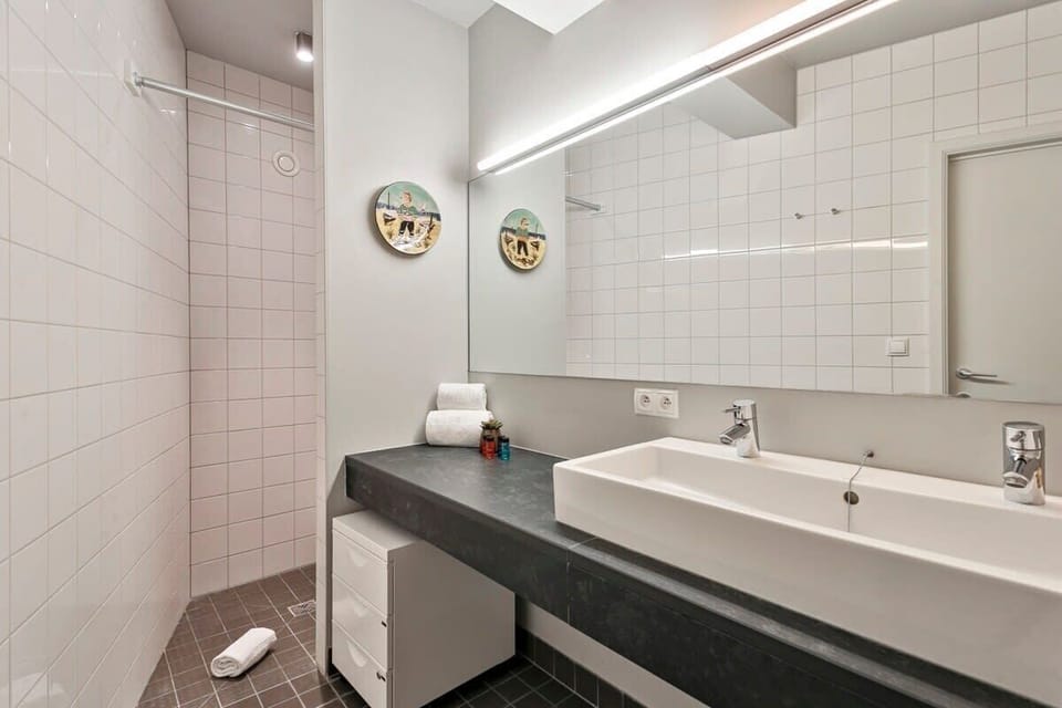 Modern bathroom with a large mirror and walk-in shower