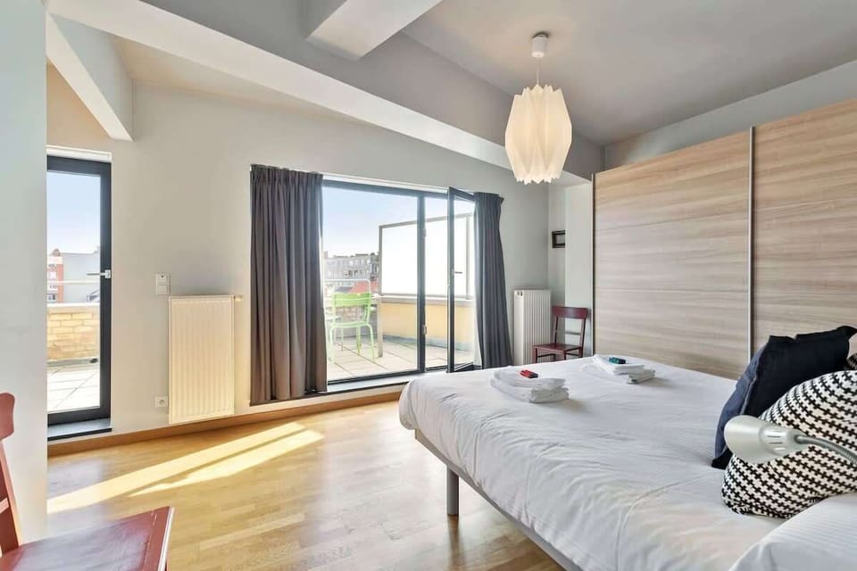 Modern bedroom with natural light and access to a private balcony.