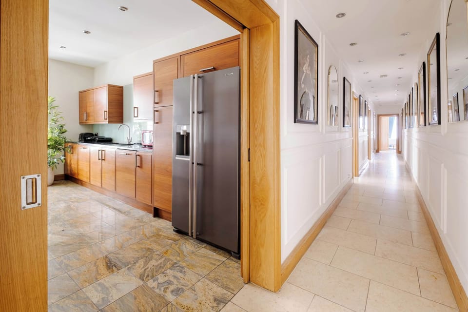 A fully equipped kitchen with a double door fridge freezer, 5 burner gas hob, Nespresso machine with pods, and a full selection of champagne, wine and martini glasses. Includes filtered water, ice dispenser, washing machine, dryer and dishwasher.