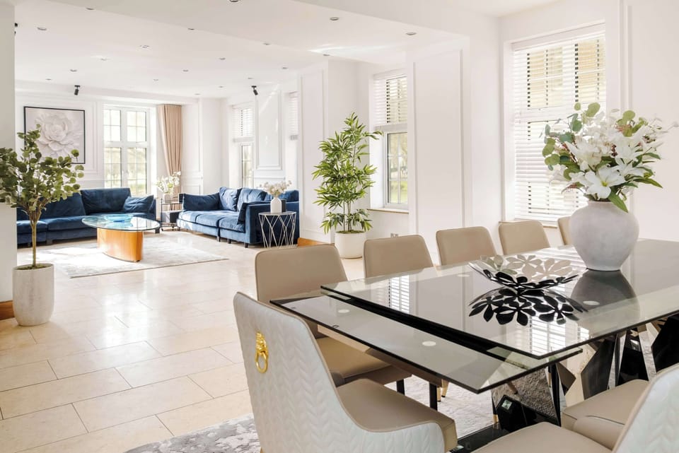 A stunning, oversized living room with breathtaking Hyde Park views, complemented by a grand dining table seating 12 guests. Unwind with a premium 77 inch OLED TV and PlayStation 5, perfect for entertainment, gatherings, and unforgettable stays.