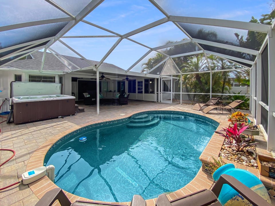 Relax in the private screened pool area with a hot tub and lounge chairs.