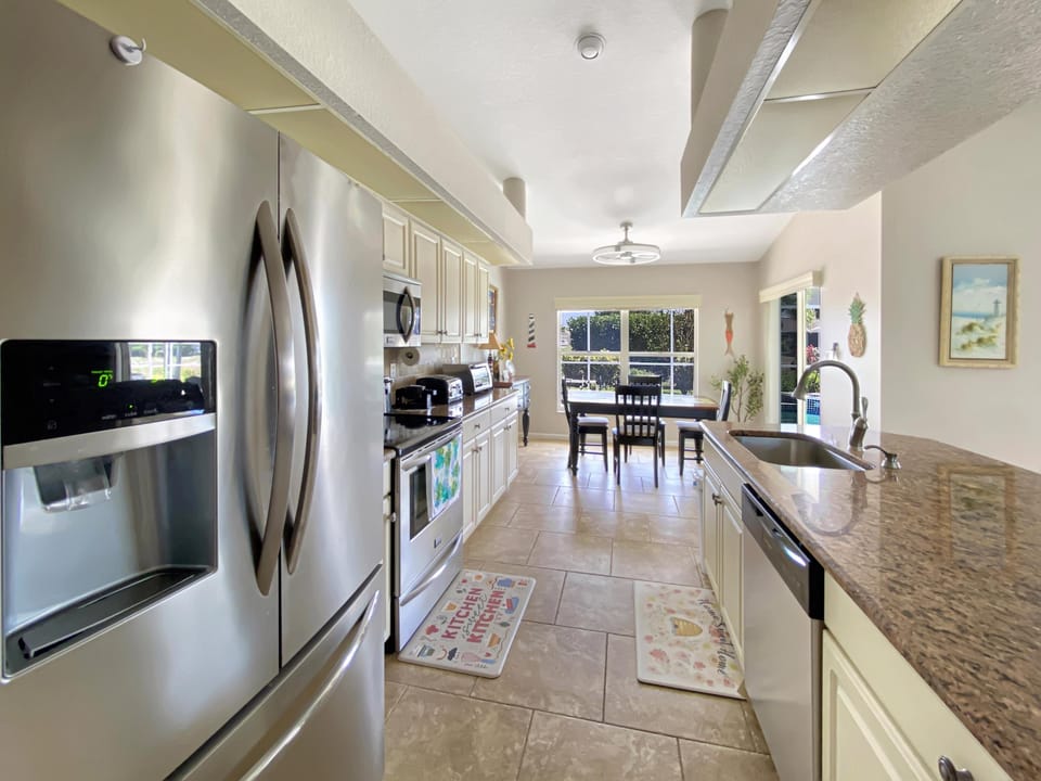 Modern kitchen with stainless steel appliances and a cozy dining area overlooking the garden.