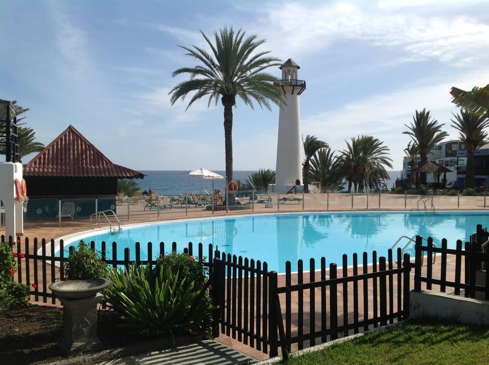 Heated communal pool of the complex with views of the lighthouse and sunbathing areas