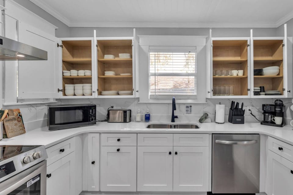 Fully stocked kitchen with modern finishes and open shelving—everything you need to cook and feel at home.