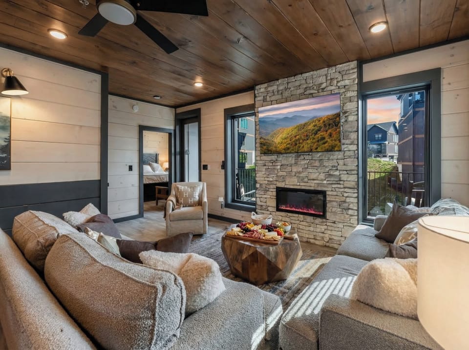 Warm living room w/ plush seating, stone fireplace & open flow into the kitchen