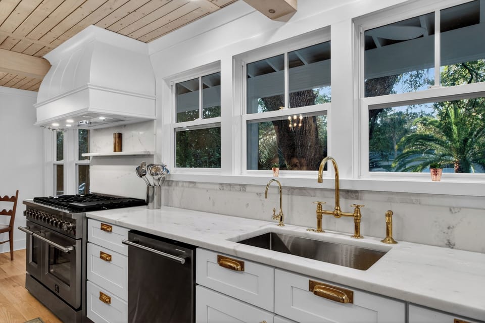 Warm modern kitchen with a spacious island, wood accents, and bright natural light.