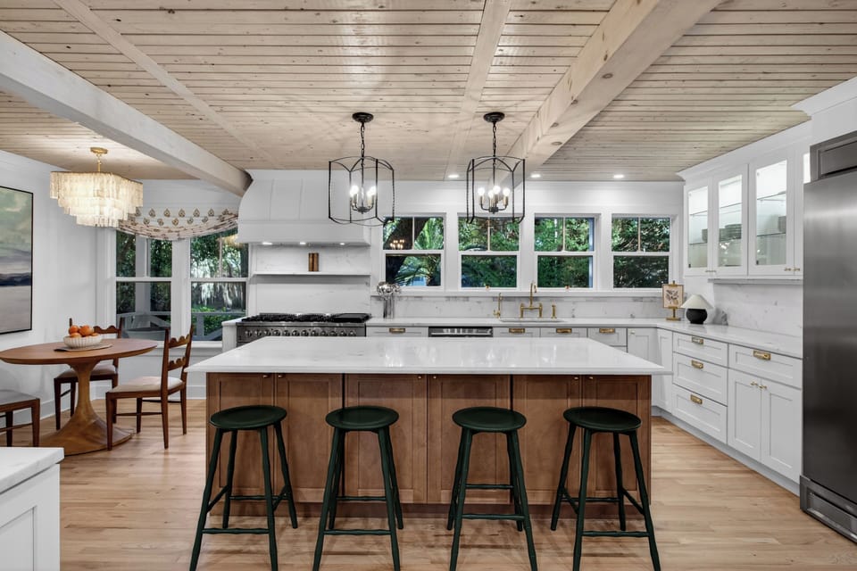 Warm modern kitchen with a spacious island, wood accents, and bright natural light.