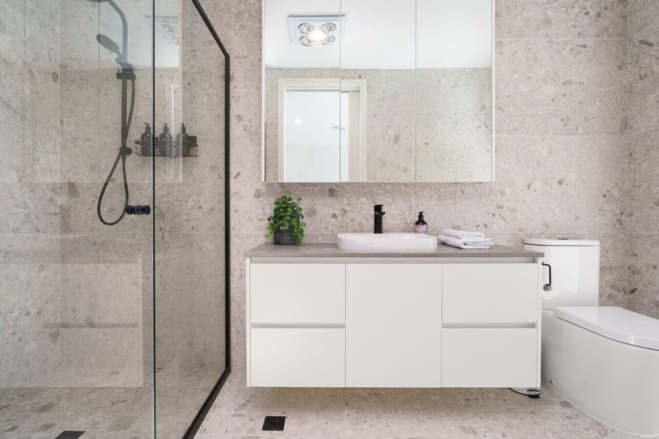 An inviting bathroom with warm stone textures and a clean, contemporary layout.