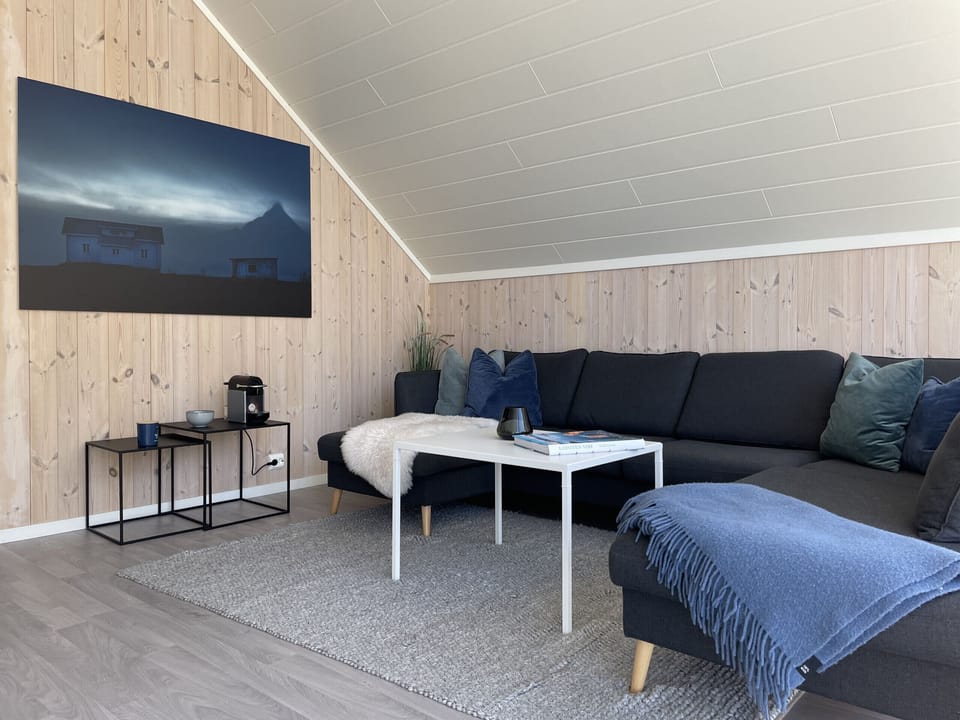 The living room upstairs has a large sofa for relaxing in front of the view and the TV