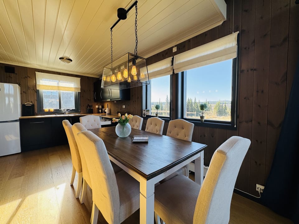 Comfortable dining space next to the kitchen for easy serving with natural light and seating for the whole family