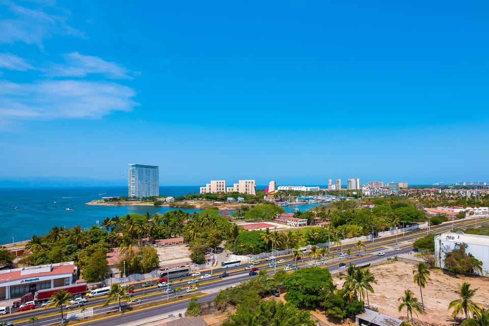 Take in the stunning bird's-eye view of the shimmering blue bay, golden beaches, and the coastal boulevard stretching into the distance.
