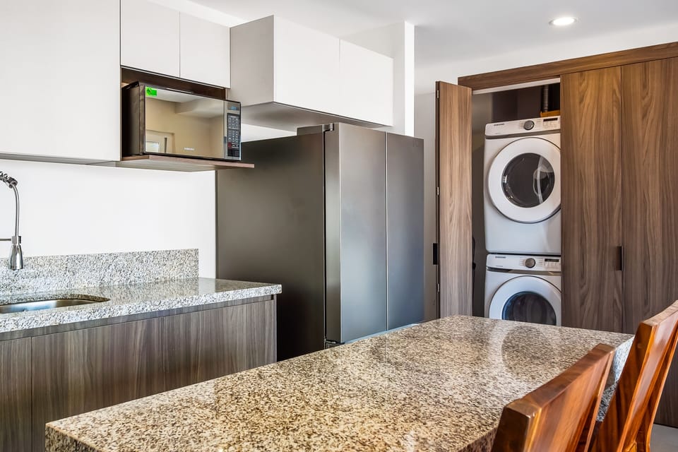 Enjoy maximum travel convenience with a stacked front-loading washer and dryer set tucked into a dedicated closet right next to the kitchen.