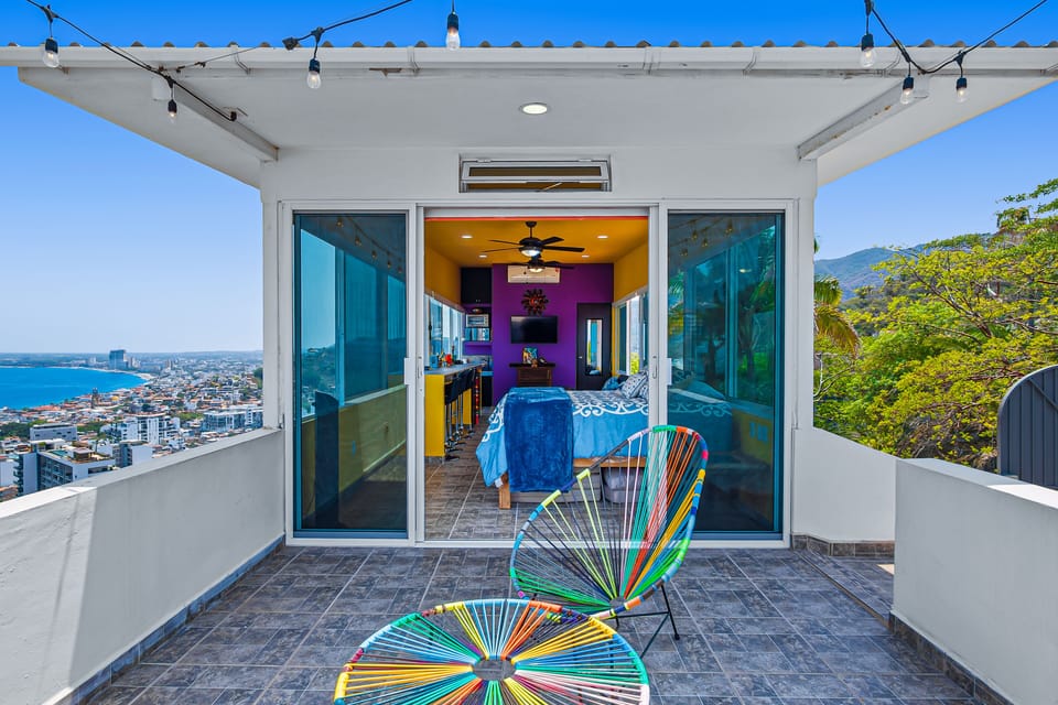 Rooftop tiled patio area looking through sliding glass doors into the colorful studio room.