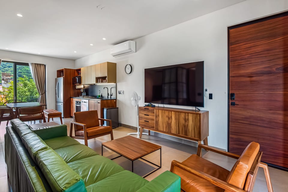 A comfortable, air-conditioned lounge area perfect for unwinding. Features chic mid-century style furniture and an open layout flowing into the kitchen.