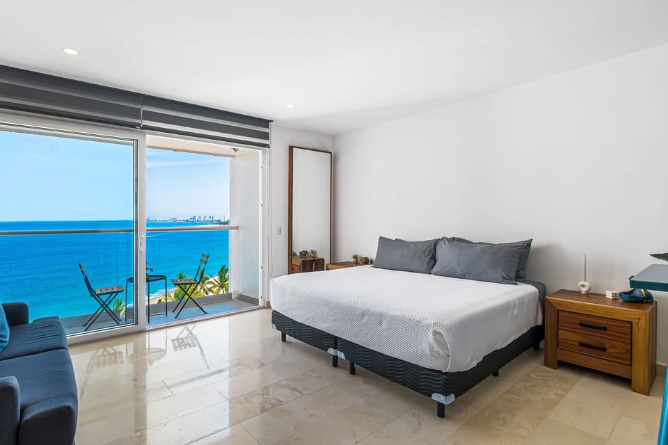 Bright and spacious bedroom with a private balcony overlooking the sea, offering the perfect setting to enjoy peaceful mornings and refreshing ocean breezes.