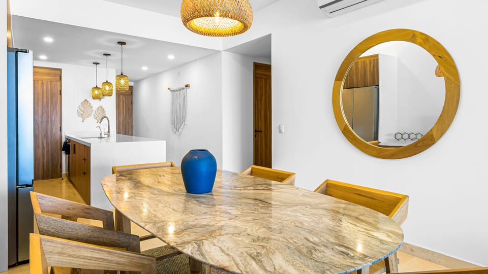 Enjoy meals together in a beautifully designed dining area with warm lighting, elegant wood finishes, and an open-concept layout perfect for gathering.