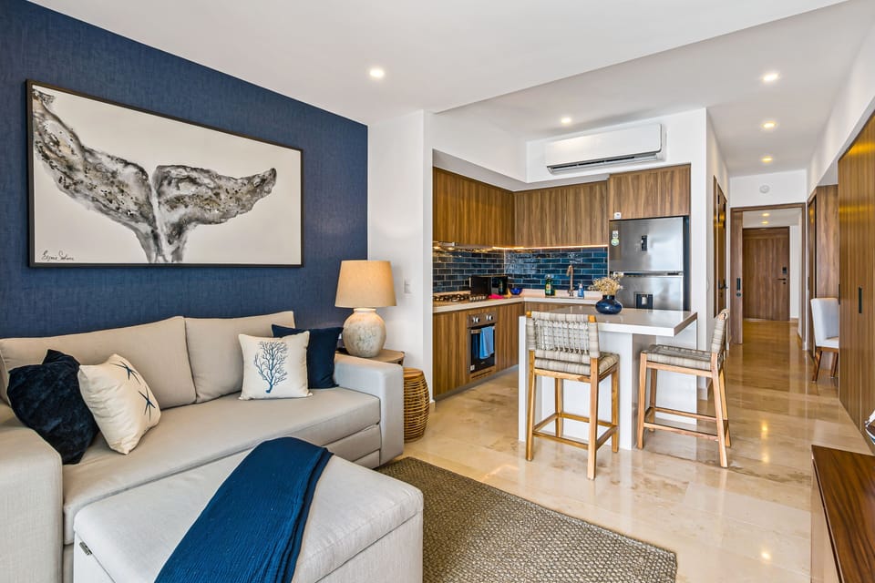 Seamless flow from the cozy living room sofa to the kitchen breakfast island and modern cabinetry.
