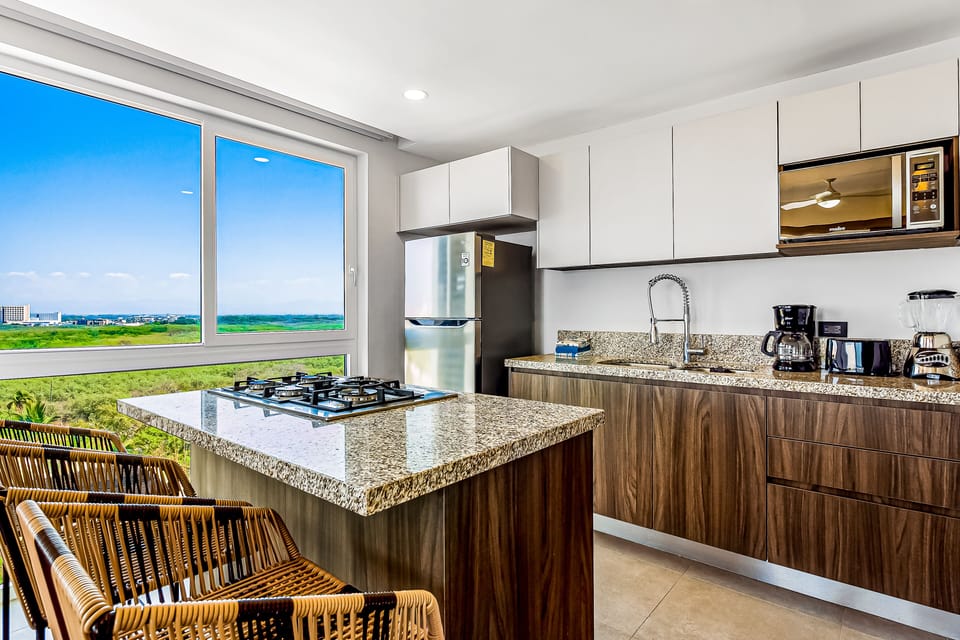 Cook with a view at this sleek kitchen island featuring a built-in gas range, polished granite countertops, and warm wood grain cabinets.