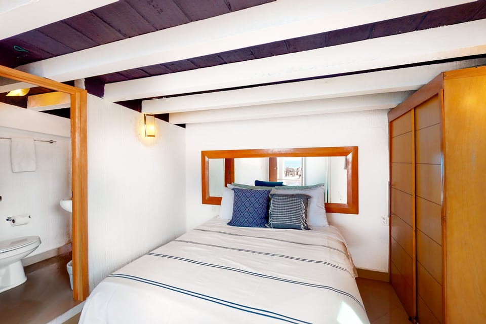 Alternative angle of the bedroom layout showcasing the bed setup and a partial view leading into the adjoining bathroom area.