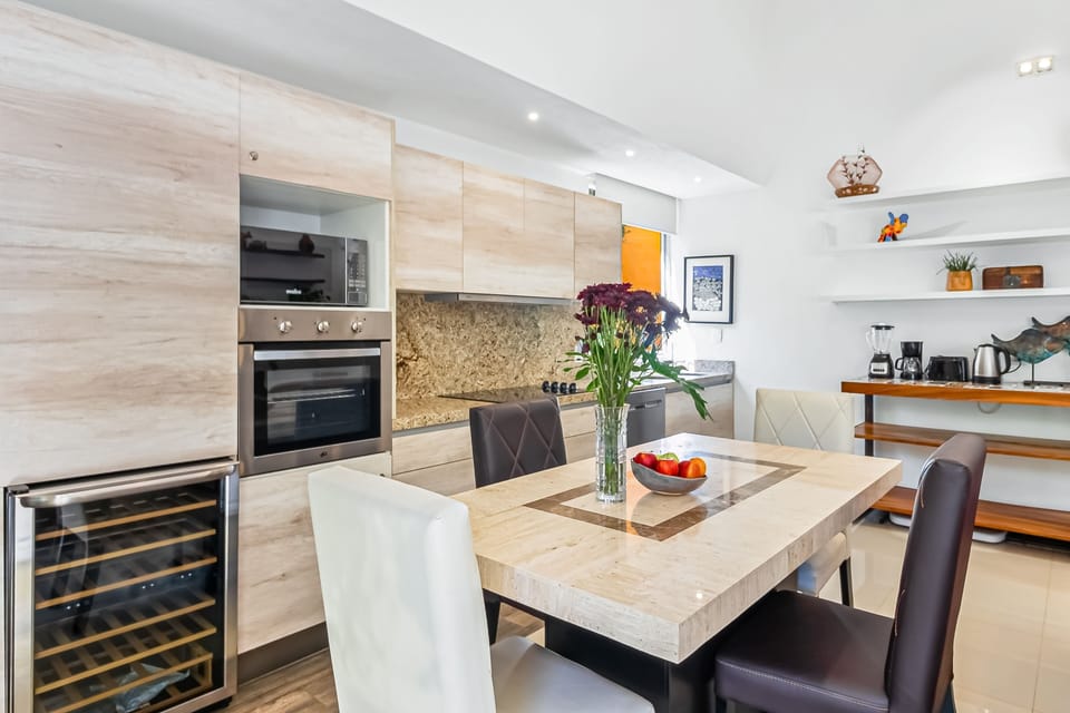 Fully equipped kitchen featuring a built-in oven and wine cooler right next to the main dining set.