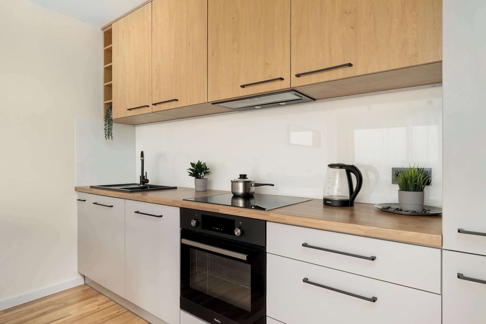 A full view of the modern kitchen cabinets with numerous cabinets, an electric kettle, and carefully selected kitchen accessories.