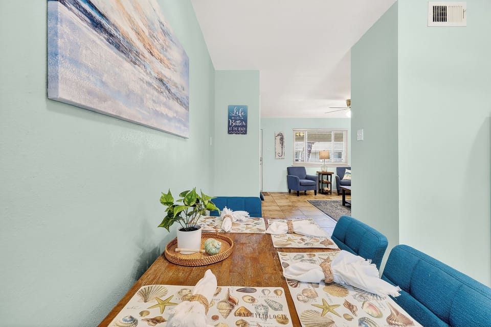 Settle into your bright dining space featuring coastal artwork, comfortable seating, and an open layout that flows into the living area.