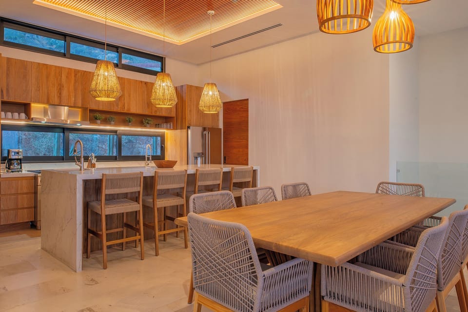 Step into your modern kitchen where warm wood and stunning pendant lights create the perfect space for cooking and gathering.