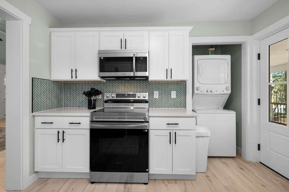 Your modern kitchen features stainless steel appliances and stylish tile backsplash, with convenient laundry right nearby.