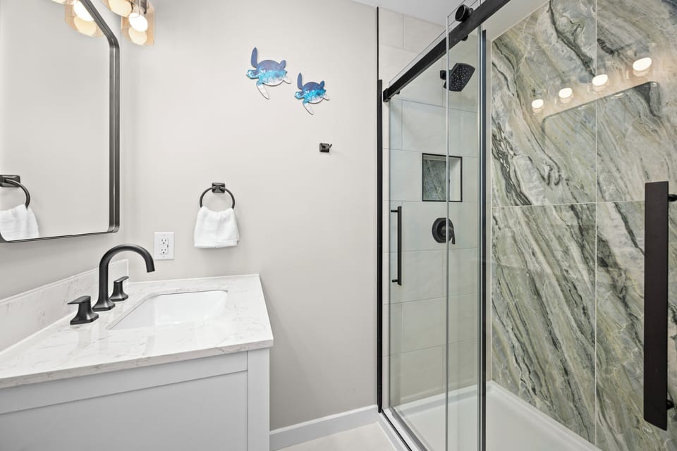 Step into your spa-like bathroom featuring stunning marble walls, modern fixtures, and a spacious glass shower that makes every morning feel luxurious.