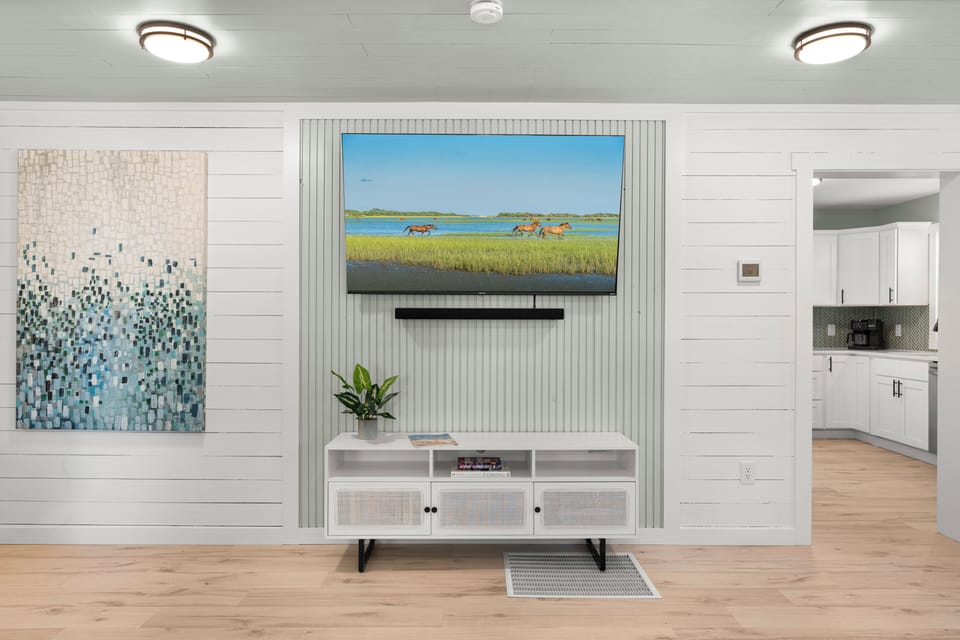 Relax in your stylish living space with wall-mounted TV and modern coastal decor creating the perfect atmosphere for unwinding.