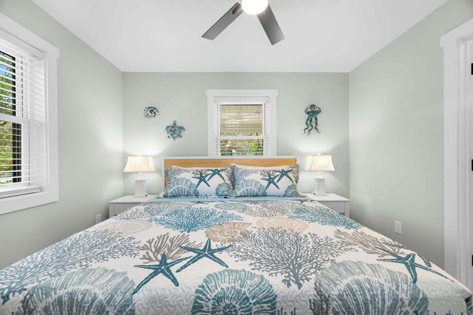 Drift off in your coastal-themed bedroom with ocean-inspired bedding, gentle sea breeze through plantation shutters, and charming nautical décor creating your perfect seaside retreat.
