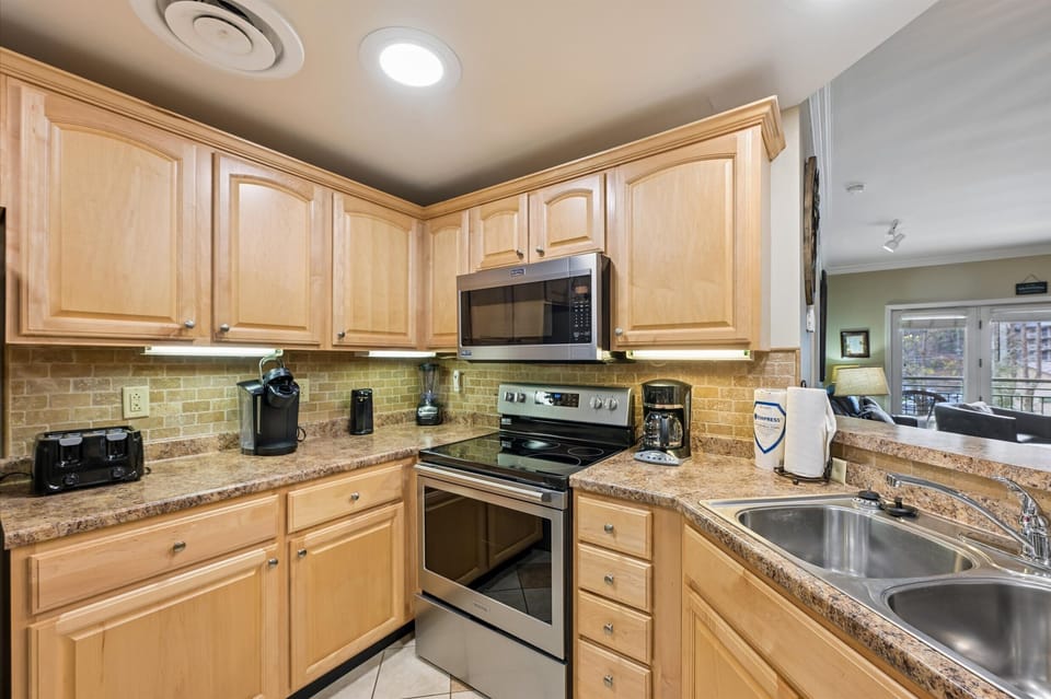 Your fully-equipped kitchen welcomes culinary adventures with granite countertops, warm maple cabinetry, and modern appliances.