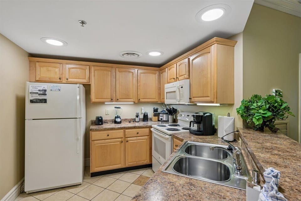 Your fully-equipped kitchen awaits with granite countertops, warm wood cabinets, and everything you need to create memorable meals during your stay.