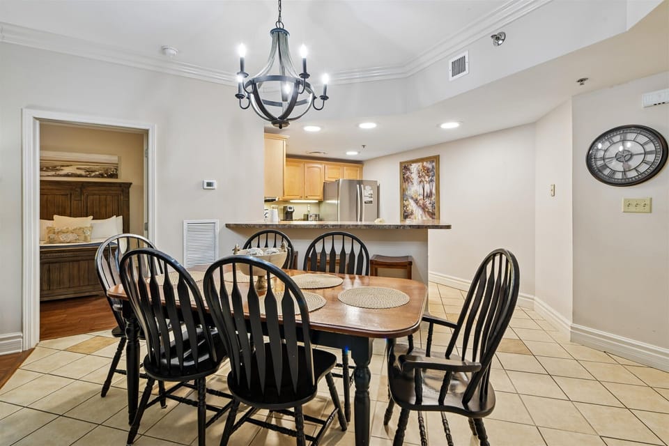 Gather around your elegant dining table for family meals beneath the charming chandelier, with the modern kitchen just steps away.