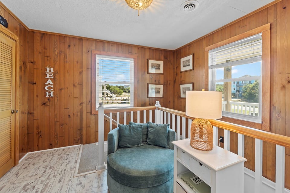Cozy Corner w/ Round Accent Chair, White Side Table w/ Lamp, Stair Railing, and Windows w/ Neighborhood Views