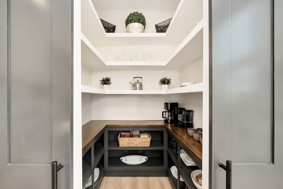 Tucked behind sliding doors, the spacious walk-in pantry keeps everything beautifully organized.