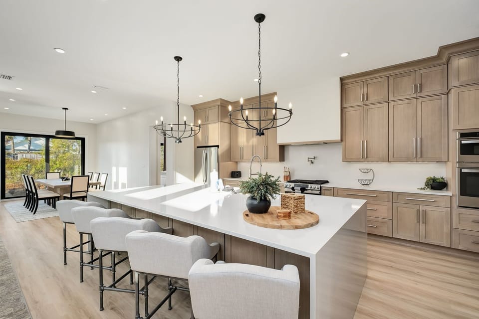 Elegant, spacious kitchen centered around a stunning waterfall island designed for gathering.