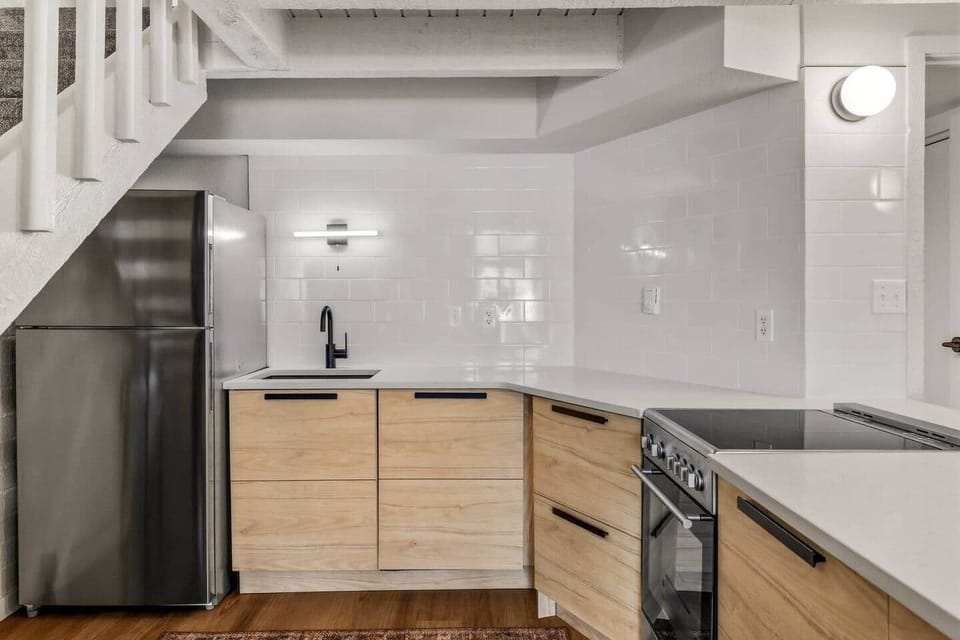 Modern, well-appointed kitchen with quartz countertops, clean-lined cabinetry, and stainless steel appliances. Thoughtful lighting and a smart layout maximize function and style, making meal prep easy and efficient during your stay.