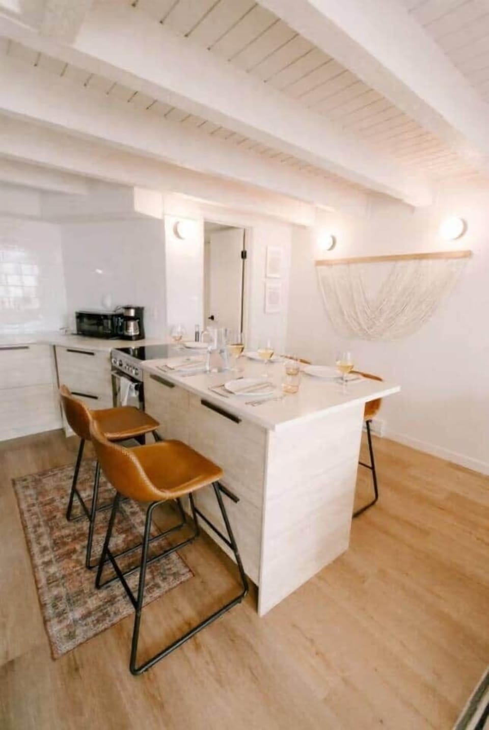 Stylish dining area with a spacious island, comfortable bar seating, and soft, ambient lighting. Clean lines, warm wood tones, and thoughtful details create an inviting space for casual meals, morning coffee, or relaxed evenings together.