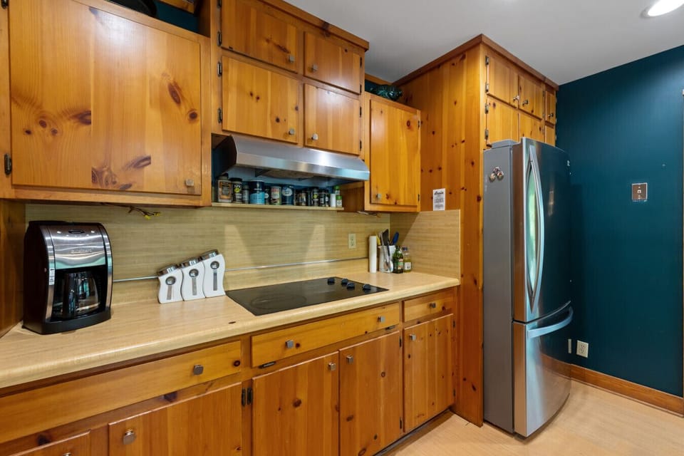 Kitchen | Wood Cabinetry & Cooktop | Stainless Fridge