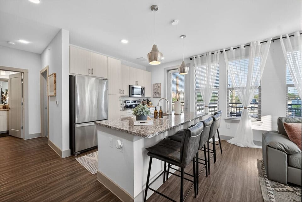 Sleek, modern kitchen featuring granite countertops, stainless steel appliances, and a spacious island breakfast bar