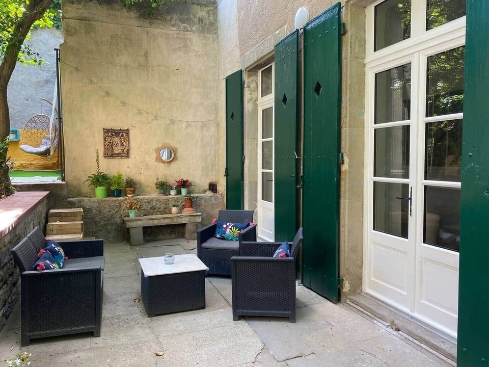 Cozy outdoor seating area with stylish furniture and greenery in a tranquil Carcassonne courtyard
